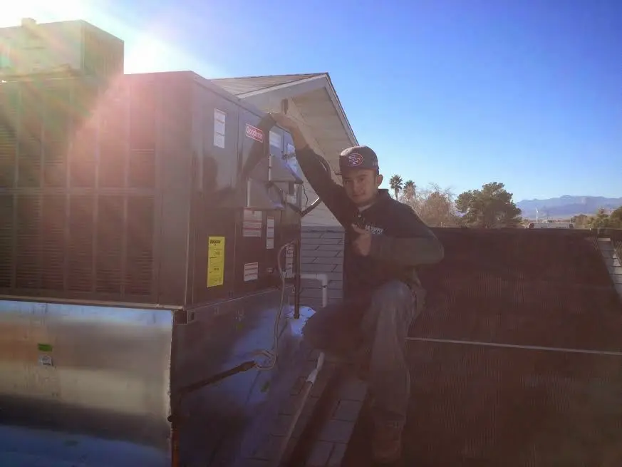 HVAC technician performing Air Duct Repair on a rooftop unit in Oxford